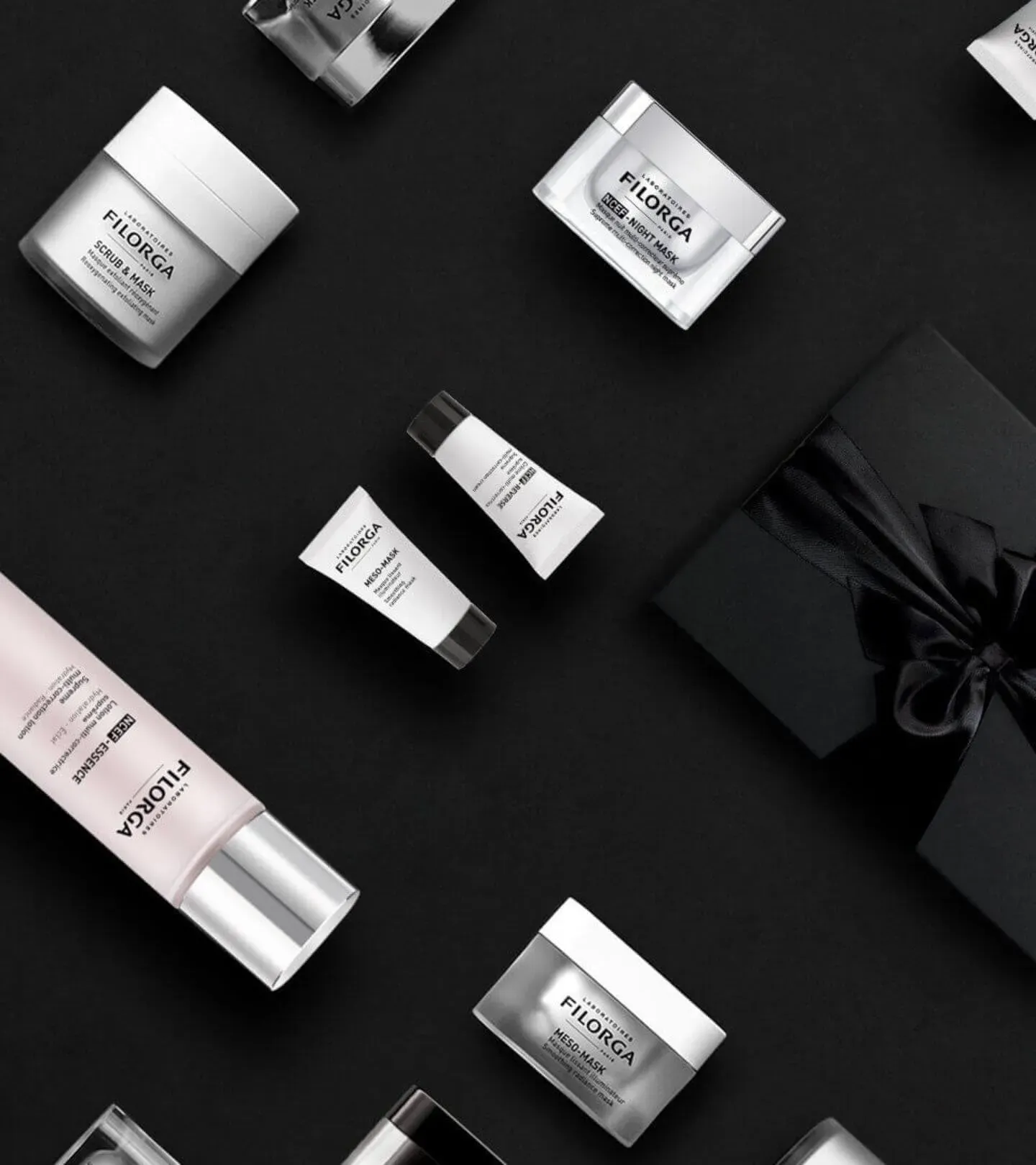 FILORGA anti-aging products lying face up on top of black background